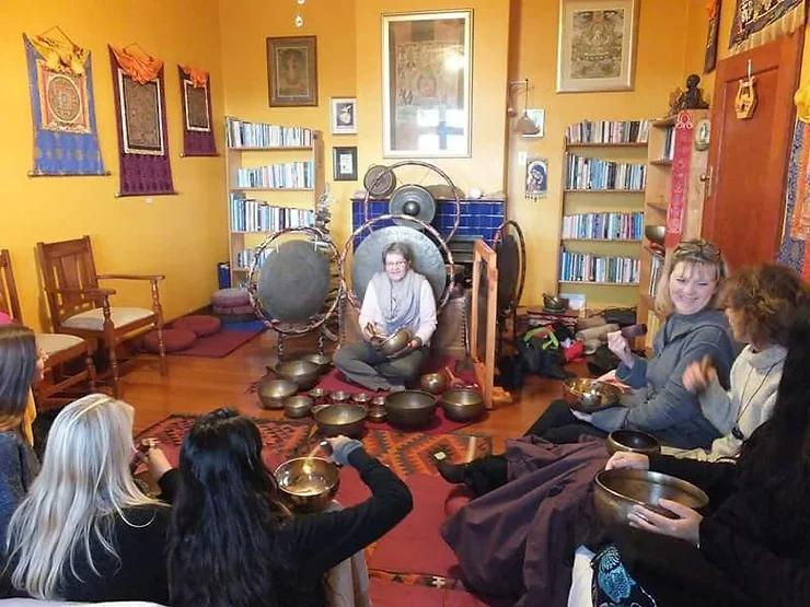 ladies sitting in a circle around Tibetan singing bowls for therapy